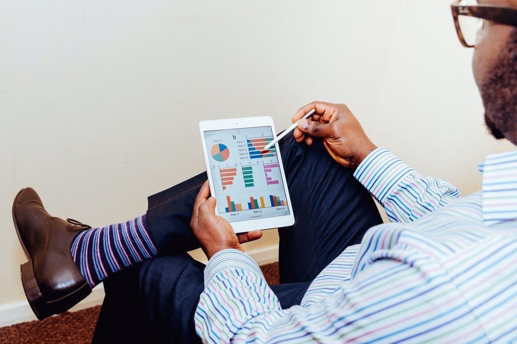 Man sits and reviews reports on laptop