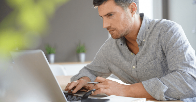 A mature man working on his laptop