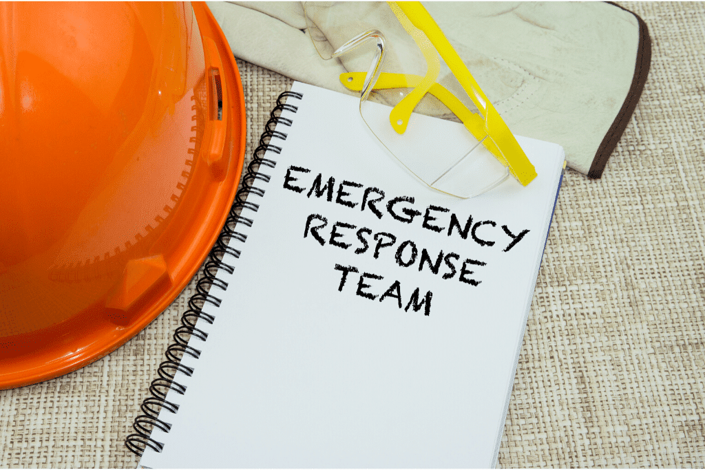 Emergency response team on a spiral notebook. Orange safety hat and safety goggles.