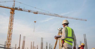 A construction surveyor standing outside at a construction location