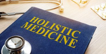 Holistic medicine book with a stethoscope on a desk.