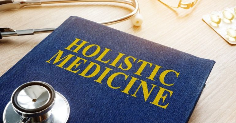 Holistic medicine book with a stethoscope on a desk.
