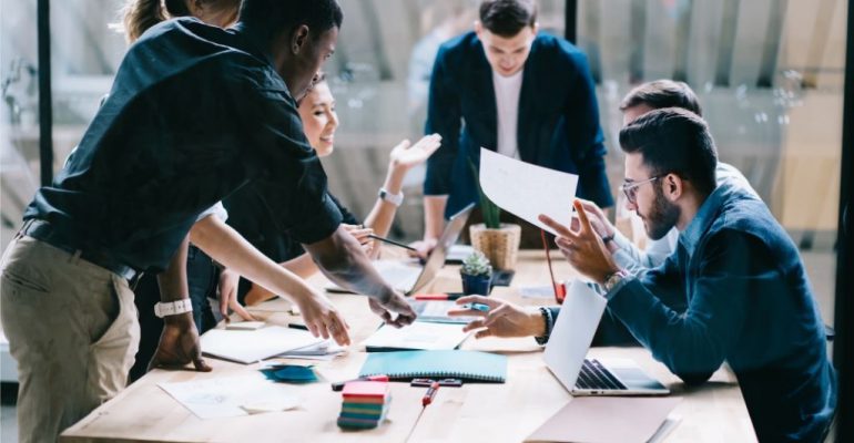 Group of young business professionals discussing notes.