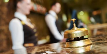 A service bell sits on a marble reception desk at a hotel