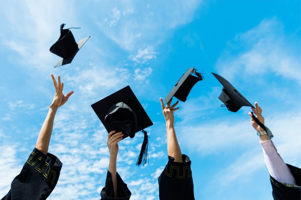 Graduation caps thrown in the air outside 