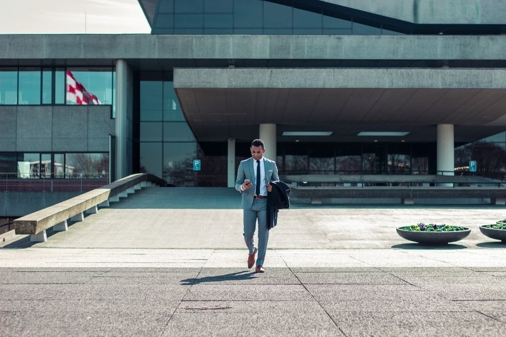 Man dressed in a suit, leaving a building.