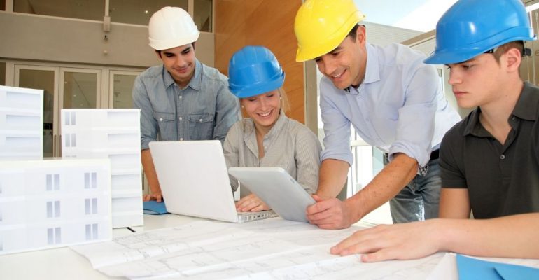 Construction management program students work with a professor in the classroom.