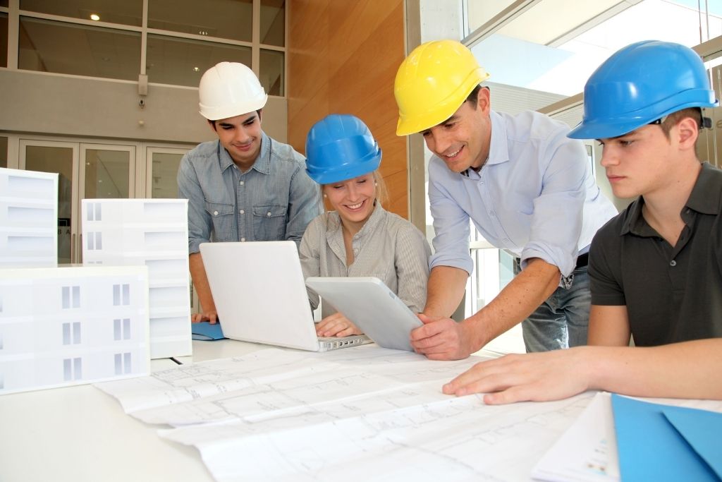 Construction management program students work with a professor in the classroom.