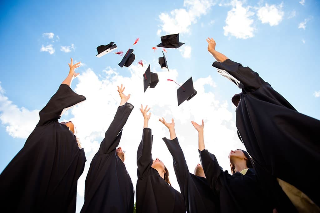 Students after graduation throwing their graduation hats in the air.