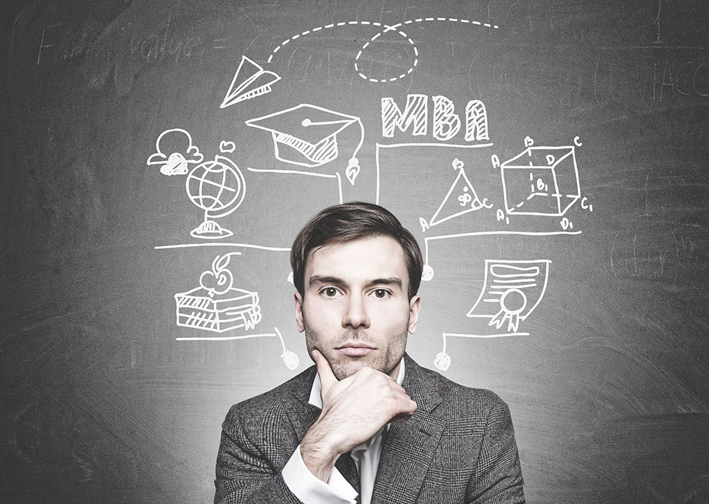 A young man stands in front of a chalkboard with ideas about what you can do with an MBA.