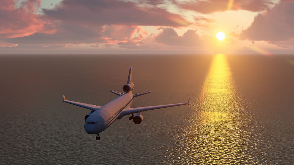 Airplane flying over water during a sunset.