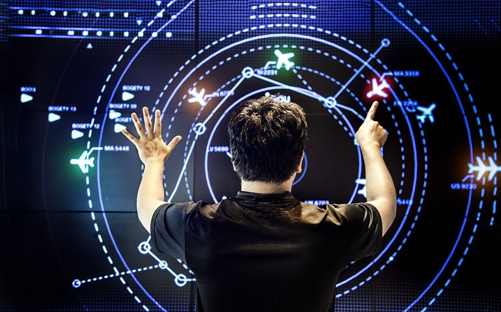 View of the back of a man controlling an aviation map as he navigates a screen with moving detect technology