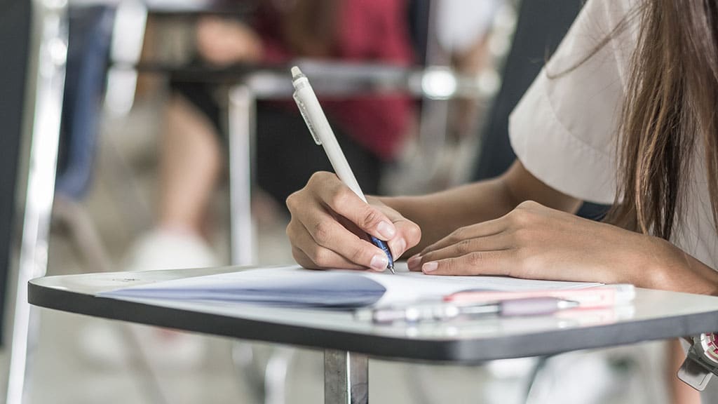 Woman does calculations while looking at financial reports and graphs.