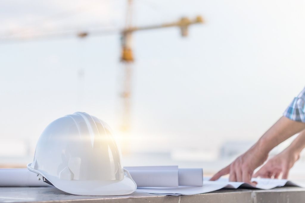 A surveying manager looking at plans on a table.