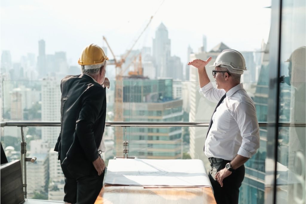 A construction manager discussing a project with his colleague at a construction site.