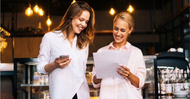 Two hospitality managers looking at their reservations for the night at the restaurant.