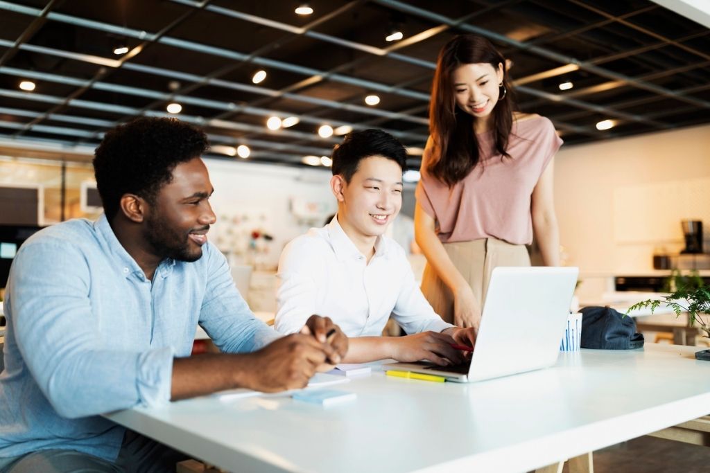 Group of entrepreneurs works on a project from a laptop.