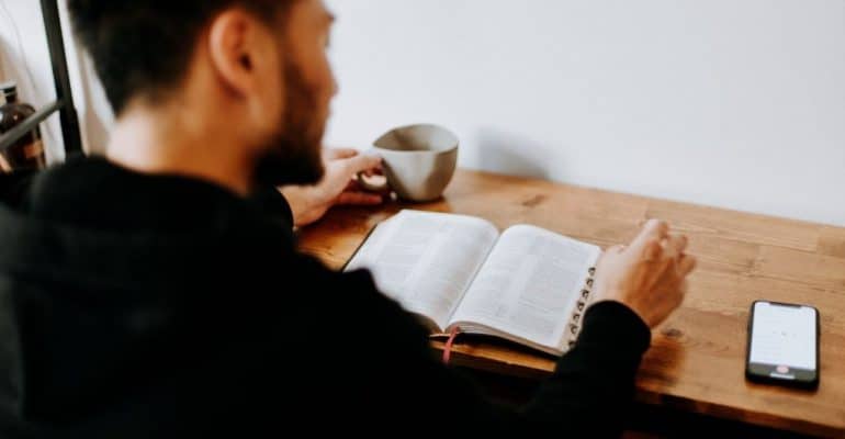 Man studies book at a table