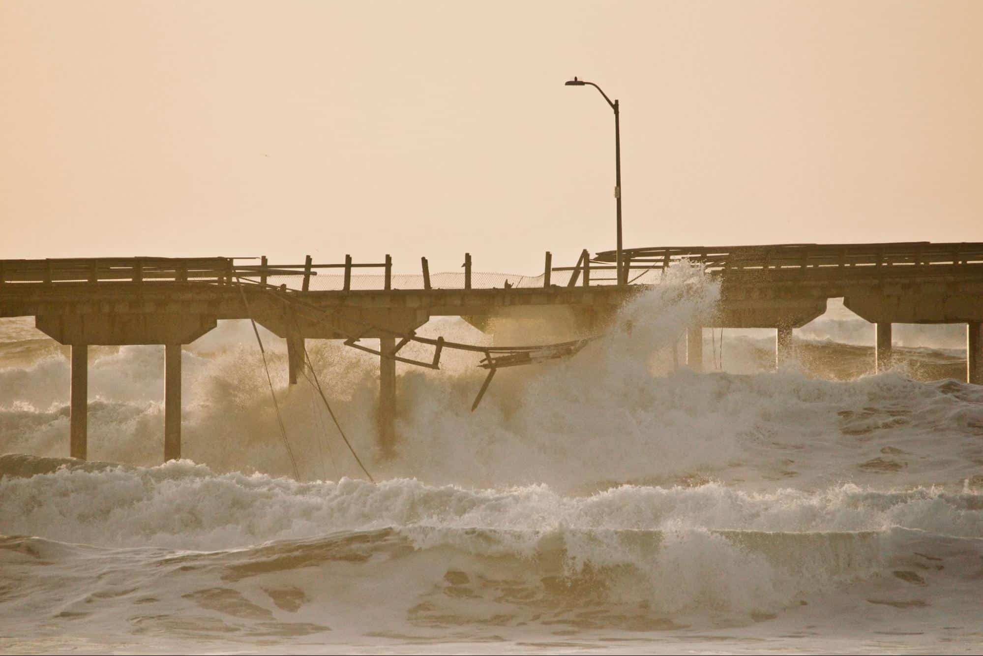 A pier falling to crushing waves from a hurricane. 
