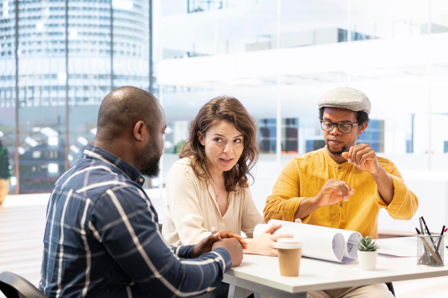 A diverse group of professionals demonstrating soft skills in the workplace by actively listening and collaborating on a project during a team meeting.