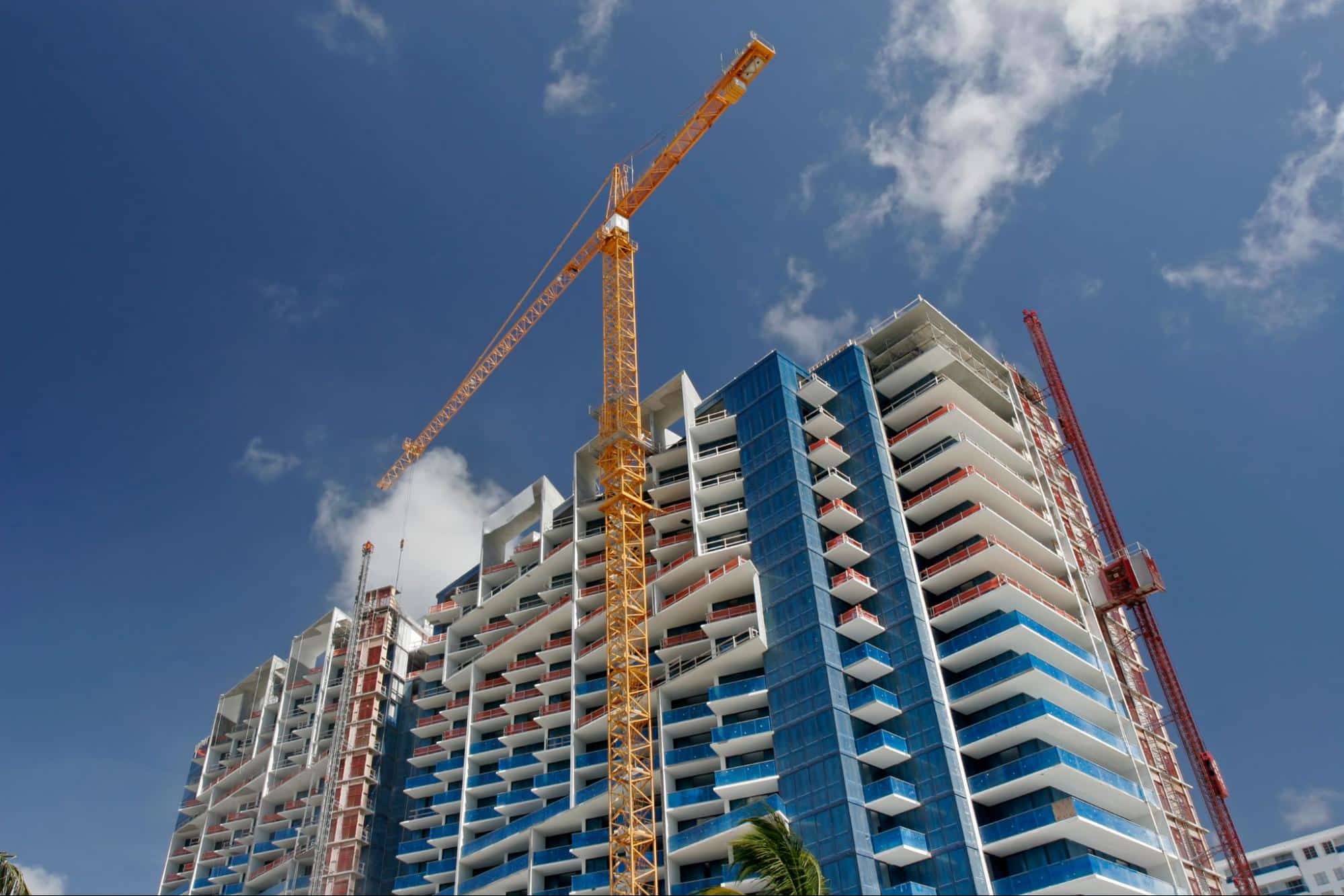 High-rise residential building under construction in South Florida with cranes and balconies during active development