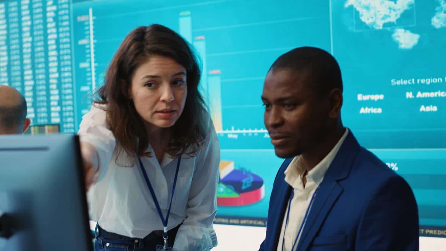 Crisis management professionals analyzing data and risk metrics on a monitor, demonstrating the strategic planning required to manage the difference between business continuity and disaster recovery.