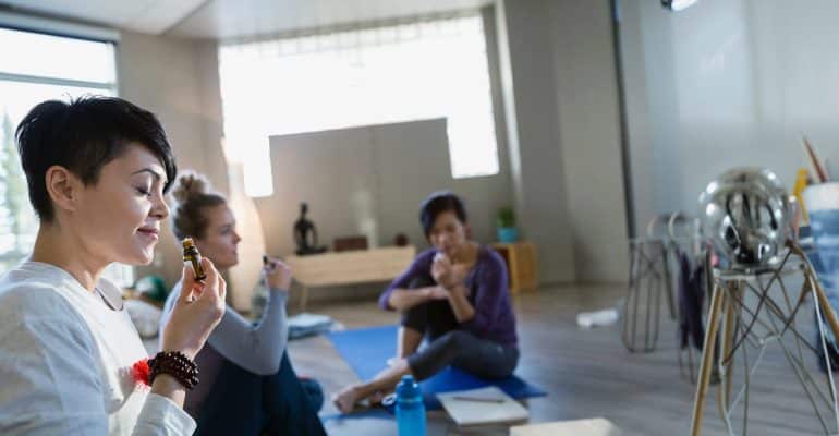 People practicing yoga and meditation in a bright wellness studio